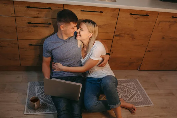 Foto vista superior de um casal caucasiano aplaudindo juntos na cozinha no chão enquanto bebe um café e usando o computador — Fotografia de Stock