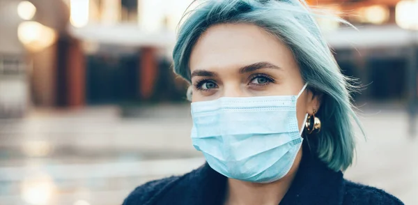 Nahaufnahme Porträt einer blauhaarigen Kaukasierin, die eine spezielle Anti-Grippe-Maske trägt, während sie in die Kamera schaut — Stockfoto