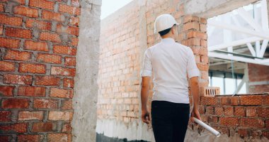 Genç Kafkas müfettişi elinde bir harita tutarken işi doğruluyor ve etrafa bakıyor.