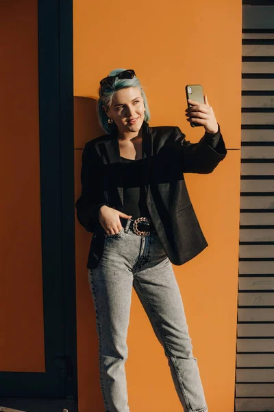 Självsäker kaukasiska dam med blått hår gör en selfie utanför framför solskenet — Stockfoto