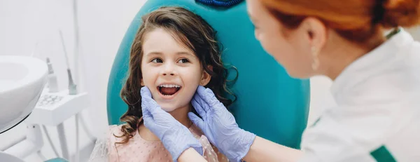 Lief kind dat glimlacht naar de dokter terwijl hij een tandoperatie ondergaat bij de stomatologie — Stockfoto