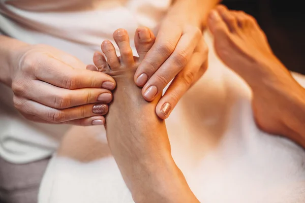 Kaukasiska kvinna som ligger på spa salongen och har en ben massage förfarande — Stockfoto