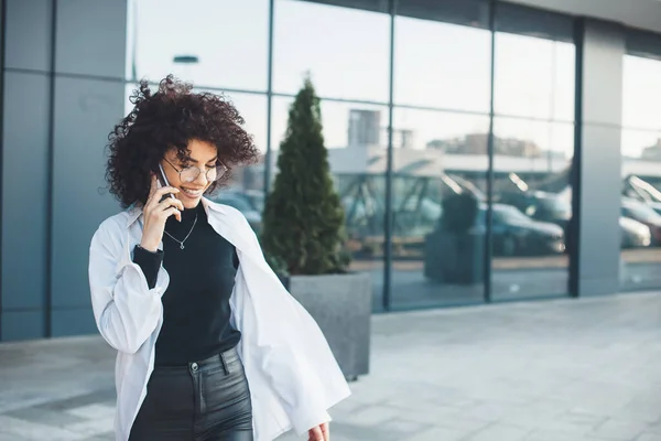 Caucásico pelo rizado mujer de negocios caucásica hablando por teléfono con un empresario fuera en una camisa blanca — Foto de Stock
