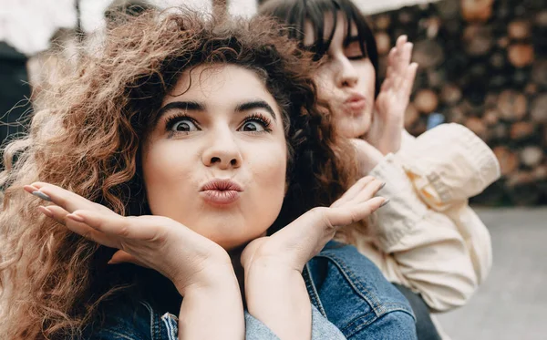 Junge Mädchen spielen zusammen und machen lustige Gesichter, während sie draußen posieren — Stockfoto