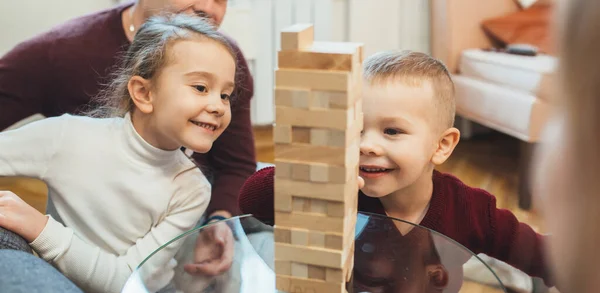 Δύο Καυκάσιοι αδελφοί παίζουν Jenga μαζί, ενώ ο πατέρας τους τους παρακολουθούν — Φωτογραφία Αρχείου