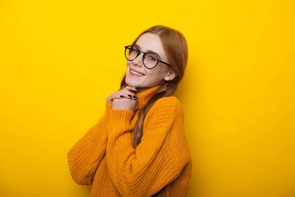 Deliziosa signora caucasica con lentiggini e capelli rossi guardando attraverso gli occhiali su una parete gialla — Foto Stock