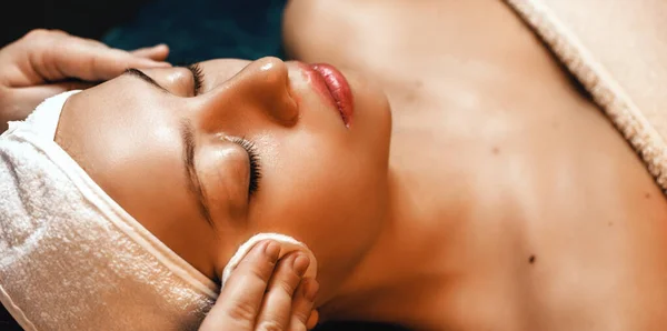 Sesja masażu twarzy z młodą kobietą leżącą w profesjonalnym salonie spa — Zdjęcie stockowe