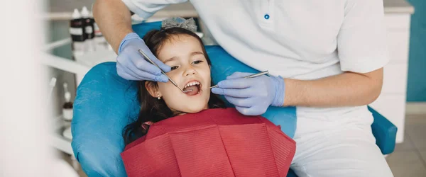 Blank meisje met geopende mond met een tandheelkundig onderzoek bij de pediatrische tandarts — Stockfoto