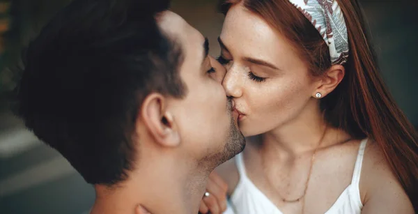 Linda mulher gengibre com sardas beijando seu amante, tendo um passeio no parque — Fotografia de Stock