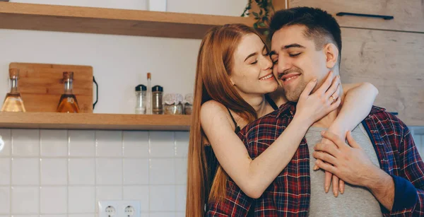Bella ragazza zenzero con lentiggini abbracciando il suo amante in cucina — Foto Stock