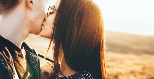 Прекрасна біла пара цілує один одного в полі протягом сонячного дня — стокове фото