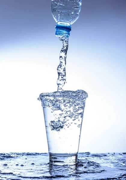 Versando acqua e spruzzando nel bicchiere con riflessione su mirr — Foto Stock