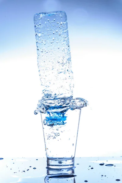 Üres üveg pohár vízben fröccsenéssel és visszaverődéssel. — Stock Fotó