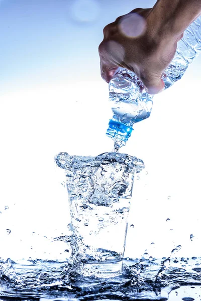 Gieten van water en spetteren in het glas met reflectie over mirr — Stockfoto