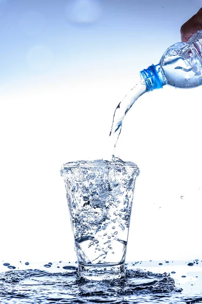 Gießen von Wasser und Spritzen im Glas mit Spiegelung auf Spiegel — Stockfoto