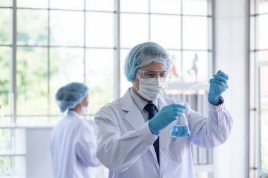 Asyalı bilim adamı ekibi laboratuvarda araştırma yapıyor..