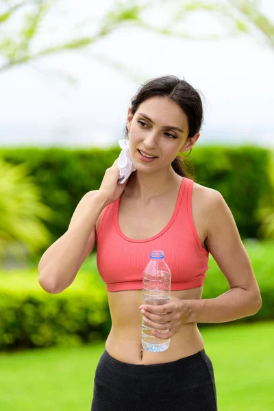 Beautiful woman runner has tired and rest for drinking water and