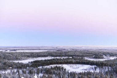 Manzara ormanı yoğun kar ve gün batımı gökyüzü ile kaplıdır. 