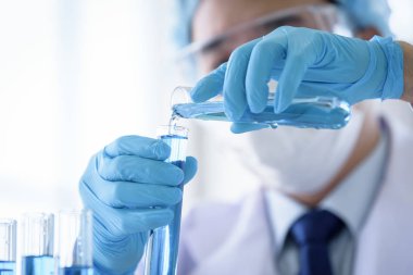 Asyalı bilim adamı bir laboratuvarda araştırma ve öğrenme yapıyor..