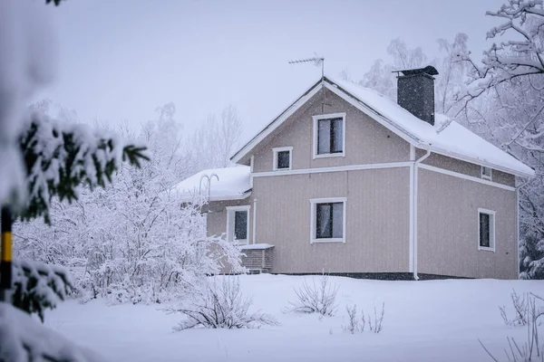 A casa na floresta tem coberto com neve pesada e céu ruim — Fotografia de Stock