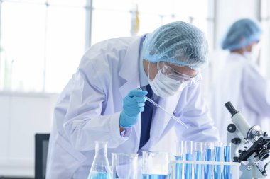 Asyalı bilim adamı ekibi laboratuvarda araştırma yapıyor..