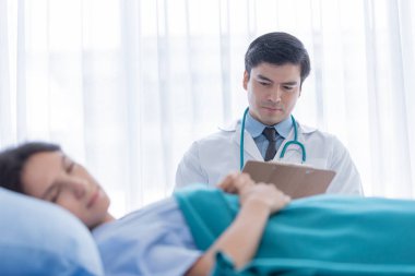 Hastanedeki ya da tıptaki hasta kadınla ilgilenen bir doktor.