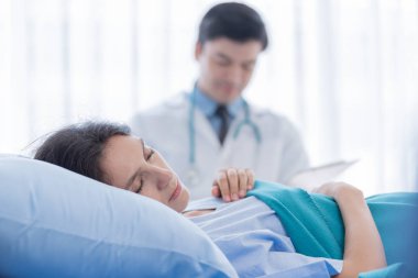 Hastanedeki ya da tıptaki hasta kadınla ilgilenen bir doktor.