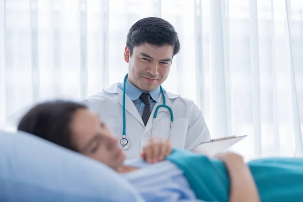 Un médico se encarga de la mujer enferma en el hospital o en el medi. — Foto de Stock