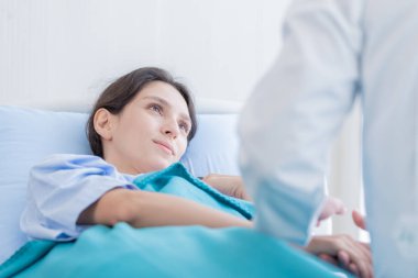 Hastanedeki ya da tıptaki hasta kadınla ilgilenen bir doktor.