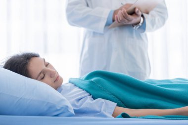 Hastanedeki ya da klinikteki hasta kadınla ilgilenen bir doktor..