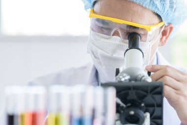 Bir laboratuarda araştırma ve öğrenme yapan Asyalı genç adam..