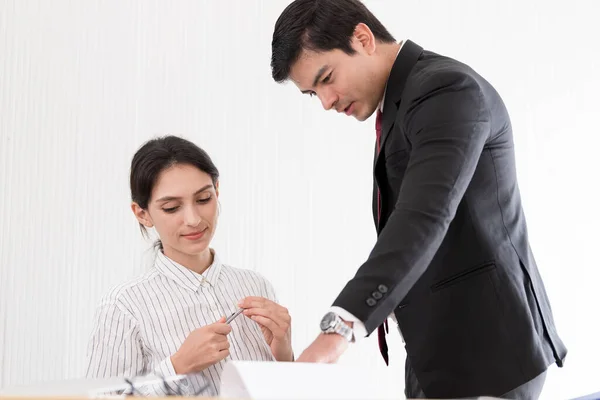 A manager and secretary working together in the office.