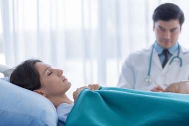 Hastanedeki ya da klinikteki hasta kadınla ilgilenen bir doktor..