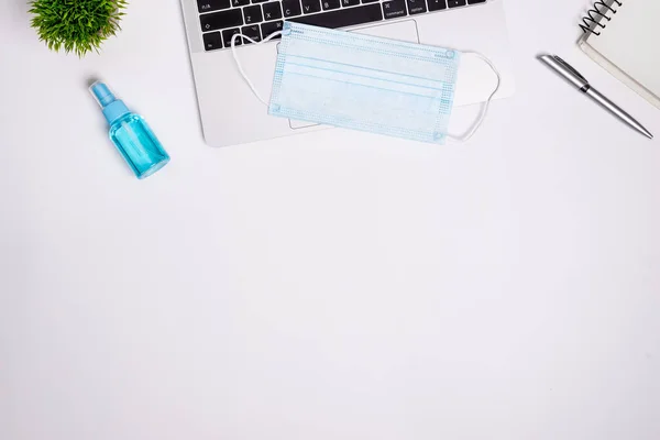 The equipment to protect COVID-19, blue mask and hand cleaner gel for preparing to work from home Isolated on white background concept.