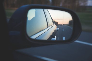 Karanlık yolda yansıması asfalt günbatımı yan ayna arka görünüm hareket eden arabanın üzerinde yukarıdaki satır ile