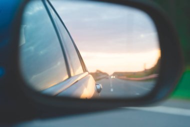 Trafik yansıma yan ayna arka görüş mavi araba on sunset yukarıda düz yol