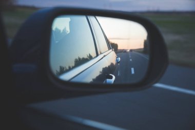 Karanlık yolda yansıması asfalt günbatımı yan ayna arka görünüm hareket eden arabanın üzerinde yukarıdaki satır ile