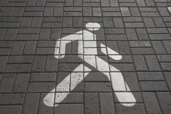 Annegata figura a piedi sulla lastra di pavimentazione. Segnale pedonale sul marciapiede. Strada e segnaletica . — Foto Stock