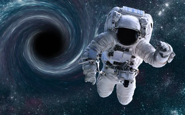 Uzayda bir yerlerde kara deliğin önünde bir astronot.