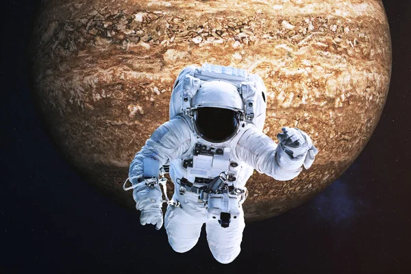 Uzak kahverengi kaya gezegenine yakın bir astronot.