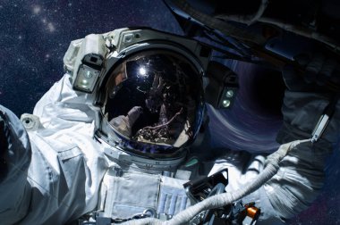 Uzayda bir yerlerde kara deliğin önünde bir astronot.