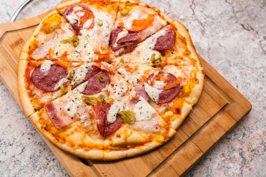 Homemade pizza on a wooden cutting Board on the table closeup