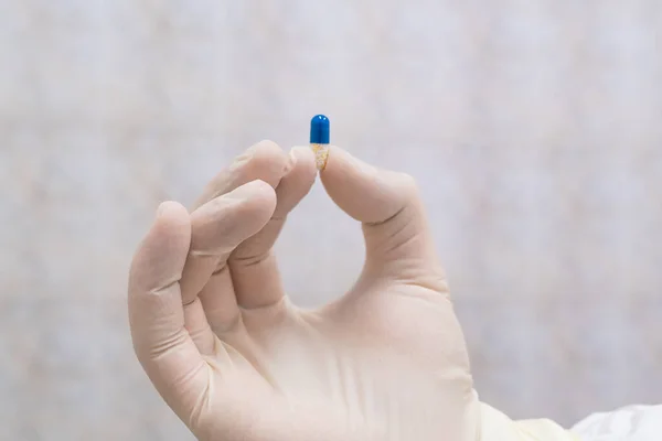 Modrá a bílá pilulka v ruce lékaře — Stock fotografie