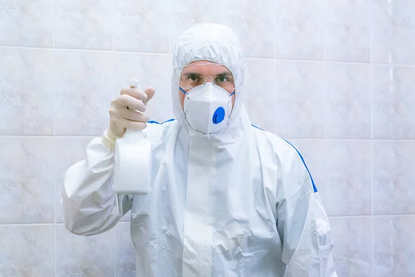 Doutor em terno protetor com spray anti-séptico nas mãos — Fotografia de Stock