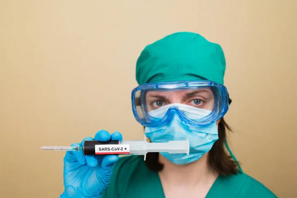 Doctora Traje Verde Guantes Azules Sostiene Jeringa Con Sangre Positiva —  Fotos de Stock