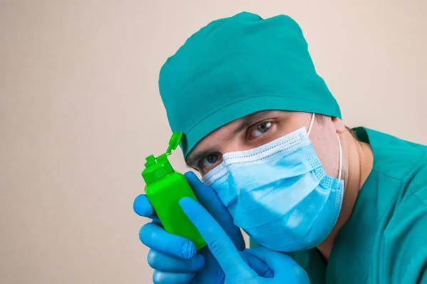 Médico Traje Verde Guantes Máscara Azul Con Frasco Antiséptico Verde —  Fotos de Stock