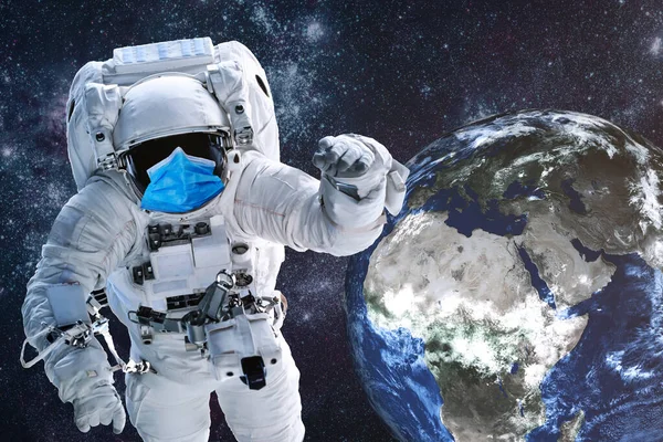 宇航员 身穿蓝色的医疗面罩 晚上在太阳系的地球附近 戴口罩很重要 科幻小说 该图像的内容由美国航天局提供 — 图库照片