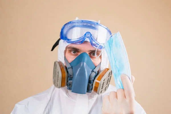 Doctor holds medical mask on the yellow background defocused. — Stock Photo, Image