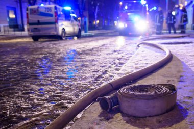 Riga, Letonya. 1 Aralık 2019. Ateş hortumu yere düştü. İtfaiyeciler ve polis, Letonya Parlamentosu üyesi Artuss Kaimins 'in evinin yandığı binanın yakınında acil durum kurtarma ekipleri..