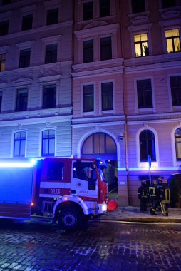 Riga, Letonya. 1 Aralık 2019. İtfaiyeciler ve polis, Letonya Parlamentosu üyesi Artuss Kaimins 'in evinin yandığı binanın yakınında acil durum kurtarma ekipleri..
